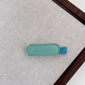 Detalle de una pinza para el pelo de resina mate azul en un panel de exhibición sobrio - 7# Clip de Pelo Azul Lago