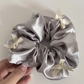 Detalle de coletero de satén plateado con elegantes lazos de cinta blanco roto - Plateado