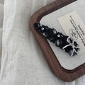 Detail of tweed fabric hair clip with silver metal bow on a vintage display tray - Black Triangle Bowknot