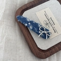 Macro detail of blue denim BB hair clip with silver bow and sequins on wooden tray - Dark Denim Triangle Bowknot