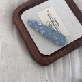 Detailed macro view of light blue denim hair clip with silver sequins on canvas background - Light Denim Triangle Clip