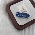 Close-up of wavy denim hair clip with silver sequins on rustic linen and wooden tray - Dark Denim Wave Clip
