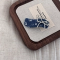 Detailed macro view of denim fabric hair clip with silver bow accent and distressed edges - Dark Denim Wave Bowknot
