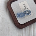 Close-up of denim bow hair clip with silver sequins and metallic bow detail - Light Denim Wave Bowknot