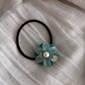 Detailed macro view of acetate flower hair tie with central pearl on fabric background - Green (5#)