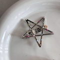 Macro di un fermaglio per capelli a stella d'argento con perline colorate su vassoio bianco - Clip a Stella Argento Pois Colorati