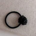 Minimalistisches schwarzes Kunstleder Rosen-Haargummi mit Gummiband auf beigem Stoff - Schwarze Rose Haargummi