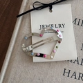 Macro detail of a heart-shaped metal clip with colorful enamel dots on a card - Silver Heart Polka Dot Hair Clip