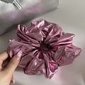 Detail of metallic pink scrunchie with shiny textured fabric held by a hand - Hair Tie / Rose Red