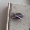 Minimalist silver ribbon hair clip with light purple cross bow on beige linen background - Purple Bow Style