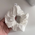 Vista macro detallada de un coletero de algodón blanco con una etiqueta de marca tejida - Blanco