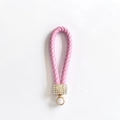 Nahaufnahme von rosa geflochtenem Leder-Schlüsselanhänger mit funkelnden Goldbeschlägen - Rosa Einfacher Stil