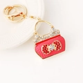 Elegant red leather mini handbag keychain with bow rhinestones and gold hardware - Red