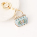Elegant light blue handbag keychain with crystal bow and sparkling rhinestone accents - Blue