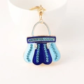 Portachiavi borsa in smalto blu con cristalli appeso a una tazza di porcellana bianca - Blu