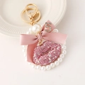 Porte-clés nœud rose avec anneau de perles et pendentif lèvres sur une assiette - Rose