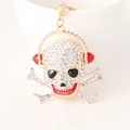 Goldener Totenkopf Schlüsselanhänger mit roten Kopfhörern und Strass für Autotaschen - Weiß