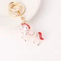 Pink rhinestone horse keychain with gold metal clasp on a clean white ceramic base - Pink