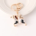 Portachiavi pony dorato con strass bianchi e criniera rosso-marrone su piatto bianco - Nero