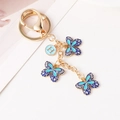 Blauwe emaille vlinder sleutelhanger met letter H hanger en gouden metalen sluiting - Blauw