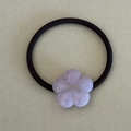 Close-up of a purple acetate flower hair tie with golden lettering and elastic cord - Purple Flower