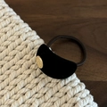 Detail van een fluwelen haarelastiekje met goudkleurig metaal en reliëfletters - Zwart Geflockt Schelp Haartouw