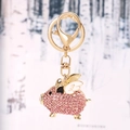 Pink rhinestone flying pig keychain with golden alloy finish and enamel wings - Pink