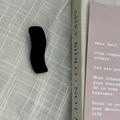 Vista detallada de una pinza para el pelo negra de terciopelo ondulado en fondo con textura - Negro