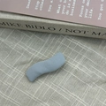 Primer plano de una horquilla de tela azul ondulada sobre un fondo neutro elegante - Azul