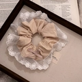 Dettaglio dell'elastico scrunchie in pizzo verde menta con ricamo e fiocco su vassoio - 1# Bordo in Pizzo Arancione