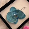 Dettaglio del fermaglio per capelli a orchidea blu scuro con perla e trama in tessuto - Blu