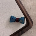 Detail der France Handmade Gold-Prägung auf der blauen Acetat-Schleifen-Haarklammer - Dunkelblau