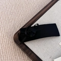 Close-up of black silk ribbon flower hair clip with a vintage bow on fabric base - Black Clip With Black Rose
