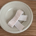 Detail of pink and white checkered bow hair clip with scalloped edges on a ceramic plate - Orange/White Plaid
