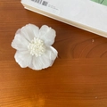 White layered chiffon flower hair clip on a wooden desk for elegant vacation styles - White