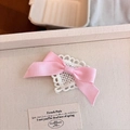 Lolita haarclip met roze strik en wit kant op een stoffen presentatieblad - Roze