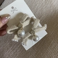 Detailed close-up of beige knitted bow earrings with gold relief and pearl pendant - Off-white Bow Set