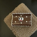 Detail view of a cute dark brown biscuit-shaped hair claw clip with a cartoon face design - Khaki Square Cheese Hair Claw (4#)
