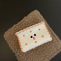 Detailed macro view of a cute biscuit-shaped hair clip with cartoon face on brown plush fabric - White Square Cheese Hair Claw (1#)