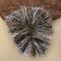 Vue détaillée du chouchou en peluche grise avec une texture douce en fil de cils - Élastique à cheveux / Blanc