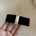 Detail van zwarte fluwelen haarclip met crème middenband en gouden metalen klinknagels - Zwarte Haarclip Met Witte Wikkel