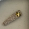 Dettaglio del fermaglio per capelli in peluche con bottone dorato e faccina sorridente - Clip Peluche Tè al Latte Smiley