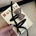Détail d'une pince à nœud marron brillant et d'un ruban en velours noir sur carte - Pince à Nœud Kaki