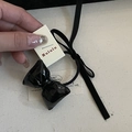 Détail d'un élastique noir en cuir verni avec long nœud papillon et rubans pour fille - Élastique à Cheveux Nœud Noir