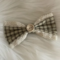 Dettaglio fiocco vintage a scacchi con bordi in pizzo e bottone in legno decorativo - Fiocco Plaid Tè al Latte