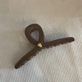 Brown matte shark hair claw clip with golden metal rivet on woven fabric background - Khaki With Gold Bead