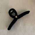 Close-up of black flocked hair claw clip with golden bead detail on woven fabric - Black With Gold Bead