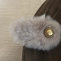 Dettaglio del bordo in peluche e fibbia dorata su un fermaglio per capelli in camoscio marrone - Clip Ovale Peluche Caffè Chiaro Etichetta Oro