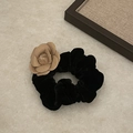 Dettaglio di elastico in velluto nero con fiore di camelia albicocca su piano in pietra - Elastico Nero Floccato Champagne Camelia (2#)