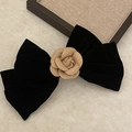 Dettaglio di un grande fiocco per capelli in velluto nero con fiore di camelia su pietra - Fiocco Nero Champagne Camelia (1#)